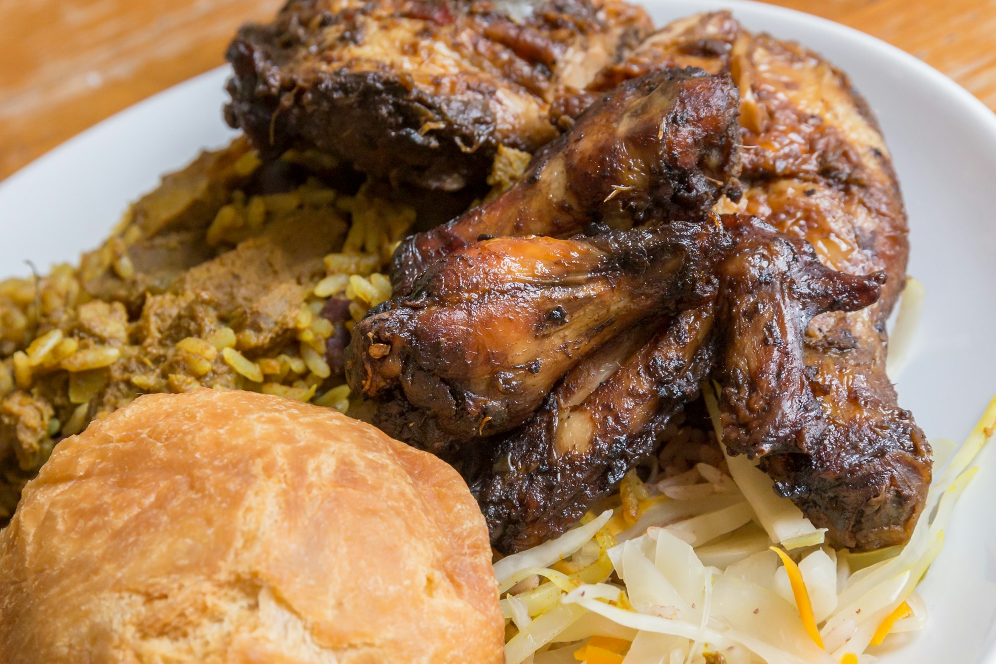Jerk chicken served with curry goat and fried dumpling, Caribbean meal made with BackYard Blendz