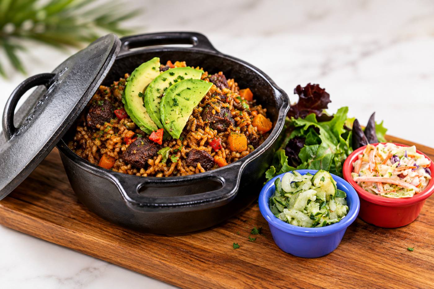 Trinidad beef pelau with pigeon peas, topped with avocado and served with salad