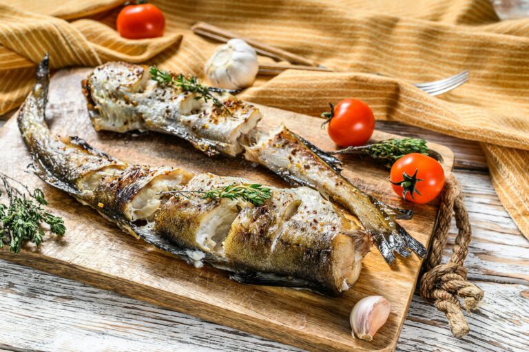 Oven baked pollock cooked in a savory marinade. White background. Top view