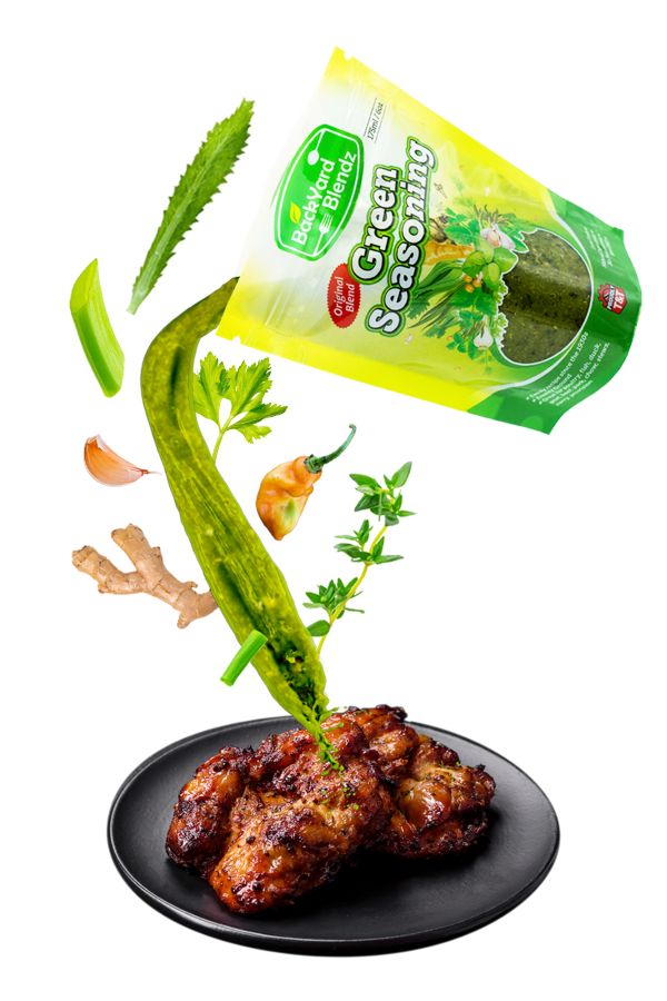 Spicy green seasoning being rubbed into chicken before cooking